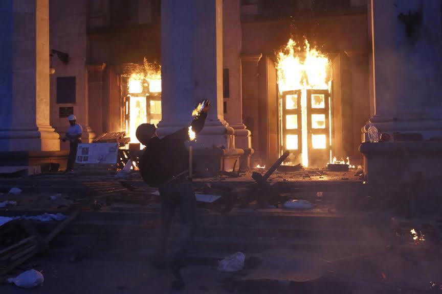 A protester throws a petrol bomb at the trade union building in Odessa May 2, 2014. At least 38 people were killed in a fire on Friday in the trade union building in the centre of Ukraine's southern port city of Odessa, regional police said.  REUTERS/Yevgeny Volokin (UKRAINE - Tags: POLITICS CIVIL UNREST)