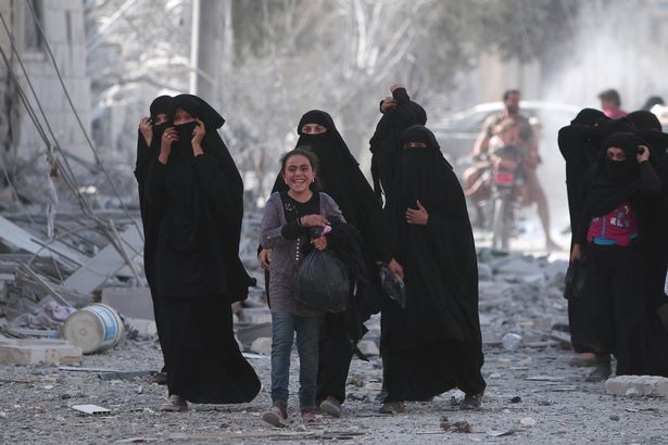 A-girl-reacts-while-walking-with-women-after-they-were-evacuated-with-others-by-the-Syria-Democratic