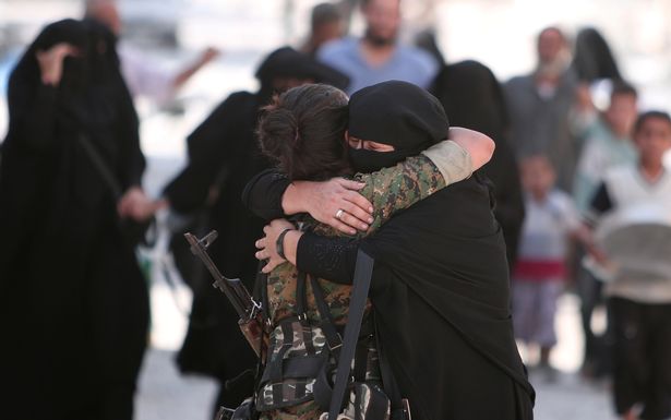 A-woman-embraces-a-Syria-Democratic-Forces-SDF-fighter-after-she-was-evacuated-with-others-by-the
