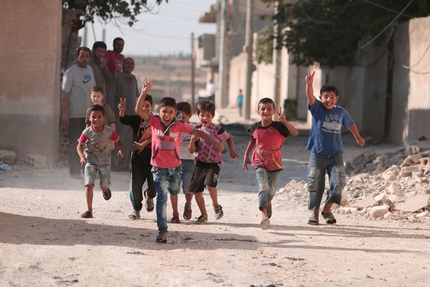 Children-flash-victory-signs-as-they-play-in-Manbij-in-Aleppo-Governorate